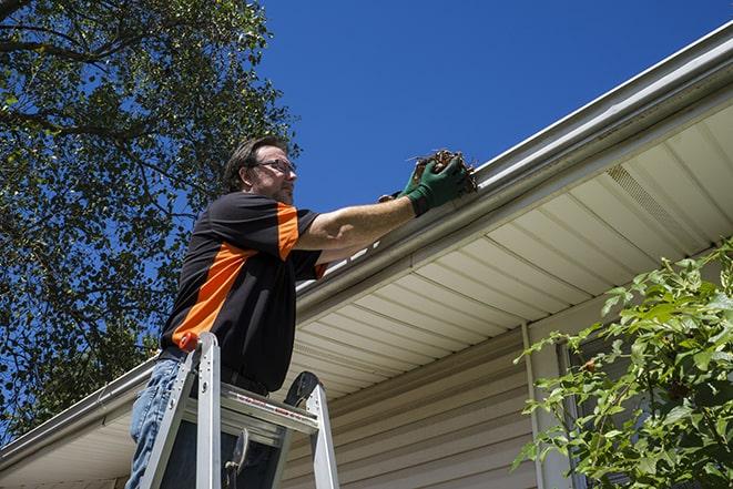 a technician replacing a section of damaged gutter in Baldwin City